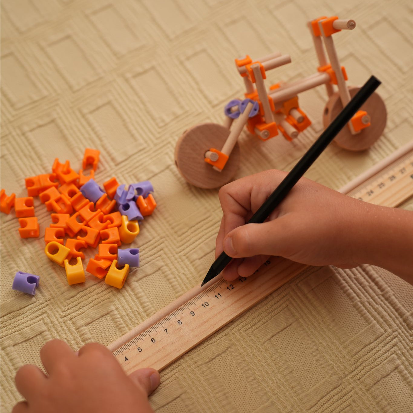 Niño midiendo y marcando con la regla del kit Beaver Vehículos