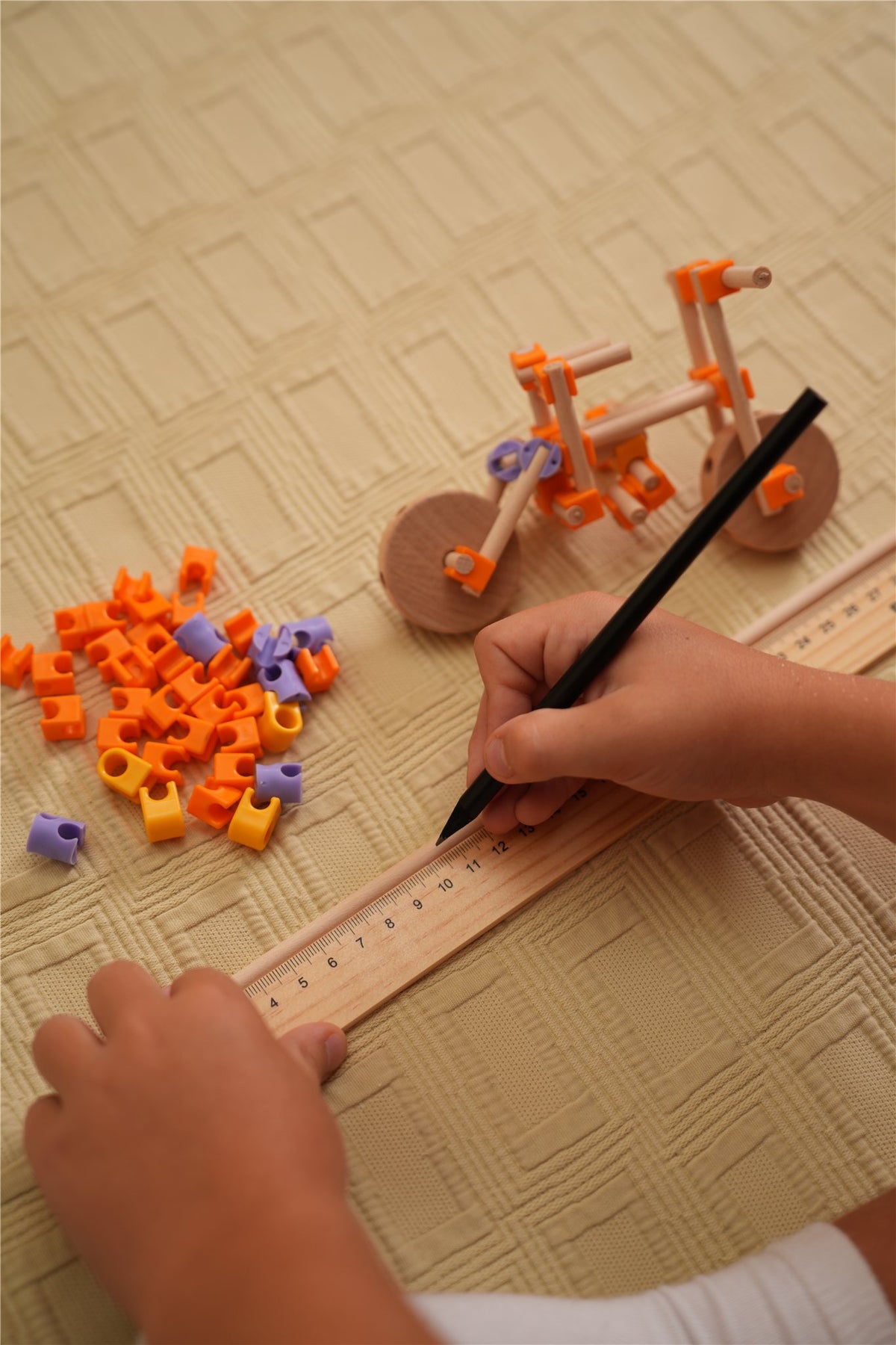 Niño midiendo y marcando con la regla del kit Beaver Vehículos