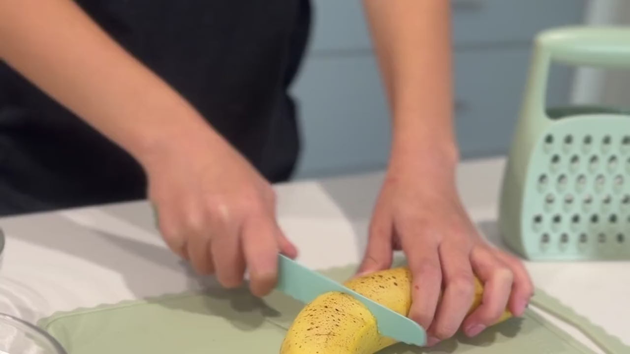 Niño cortando un plátano con el cuchillo KiddiKutter